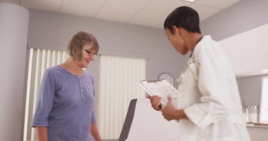 Olgun kadın hasta genç bir doktora danışıyor.