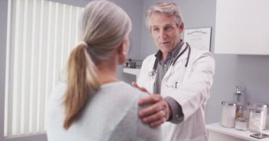Erkek kıdemli doktor hastayı rahatlatıyor