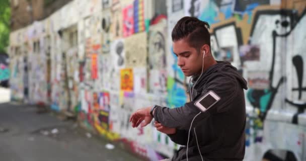 Spanyol Férfi Kocogó Ellenőrzi Fitness Nyomkövető Sikátorban Hűvös Graffiti Millenniumi — Stock videók