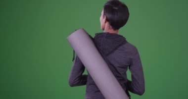 Dersin yeşil ekranda başlamasını bekleyen yoga minderli sağlıklı siyahi kadın. Anahtar ya da birleşik olmak üzere yeşil ekranda.