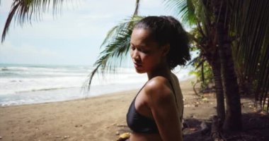 Karışık Asyalı ve İtalyan bayan sporcu sahilde terliyor. Sahilde duran çok ırklı milenyum kadını antrenmandan yoruldu. 4k