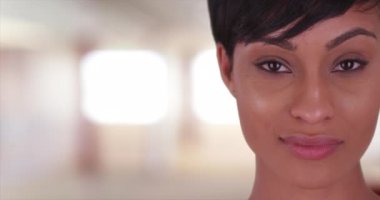 Güzel bir kadın kameraya bakıyor. 20 'li yaşlarda, kısa saçlı, siyah bir kadının yüzünü kapatın..