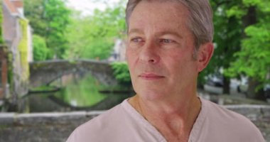 Sıkılmış Kafkas beyefendisi, Bruges 'deyken etrafını soğukkanlılıkla gözlüyor. Belçika 'da seyahat eden yaşlı adam etrafa bakınıyor. 4k
