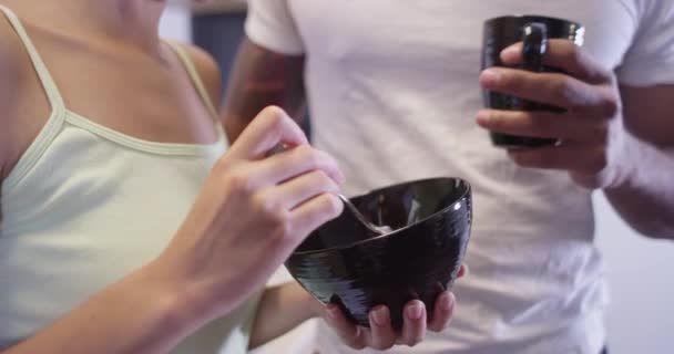 黑人和拉丁夫妇站在厨房里吃早饭和喝咖啡 — 图库视频影像