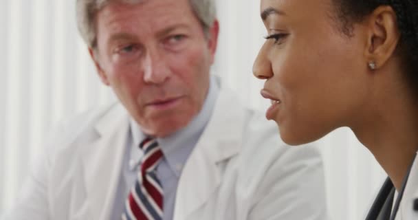 Dos Doctores Compartiendo Sus Opiniones Profesionales Sobre Expediente Del Paciente — Vídeos de Stock