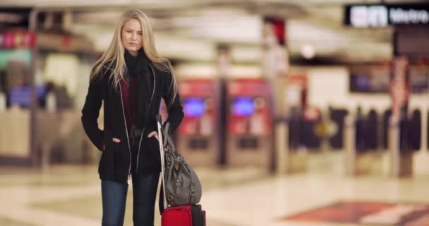 年轻的金发白人女子在火车站时随便摆姿势 一个现代化的火车站 漂亮的女旅人呆呆地凝视着摄像机 — 图库视频影像