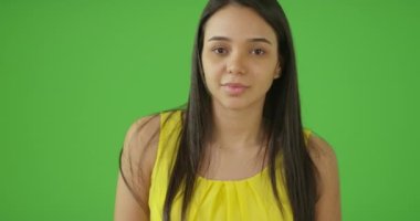 Mutlu genç bir kız yeşil ekranda bir portre için poz veriyor. Anahtar ya da birleşik olmak üzere yeşil ekranda.