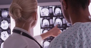 Kadın doktorun hastaya röntgenleri açıklarken yakın plan
