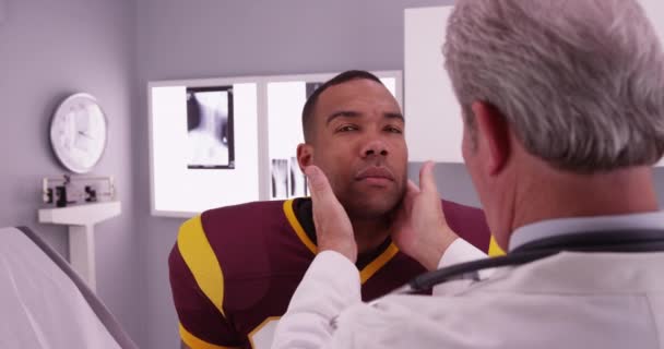 医師による検査首を持つ黒人大学選手 — ストック動画