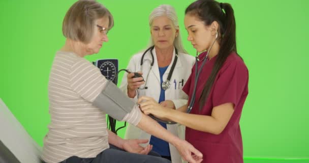 緑色の画面にカフで血圧を取るために医師の訓練看護学生 緑の画面でキーまたは構成されます — ストック動画