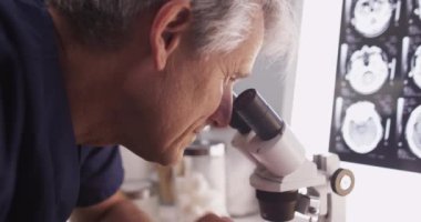 Mikroskopla analiz eden zeki erkek radyoloji uzmanı.