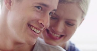 Birbirine aşık genç çiftin gülüp kucaklaşması.