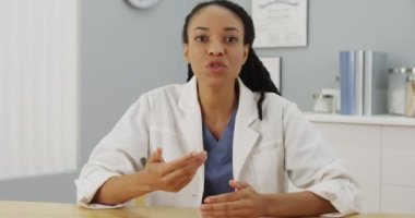 Siyah kadın doktor kameraya konuşuyor.