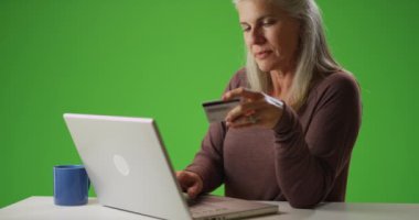 Beyaz, orta yaşlı bir kadın online alışveriş yapıyor.