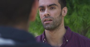 Komik bir hikaye anlatan, gülümseyen ve şakalaşan arkadaşa tepki veren bir adam.