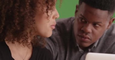 Yeşil ekranda dizüstü bilgisayar kullanan iki genç siyahi iş adamı. Anahtar ya da birleşik olmak üzere yeşil ekranda.