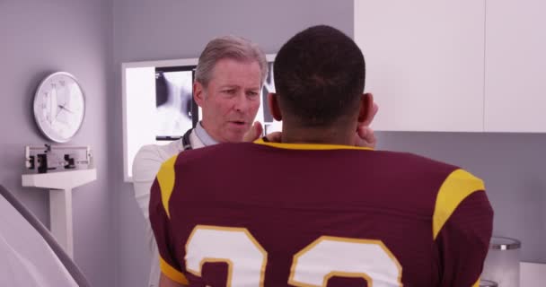 アフリカ系アメリカ人の選手で 医師による首の怪我の検査 — ストック動画