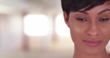 Güzel bir kadının kameraya bakışına yakın çekim. 20 'li yaşlarda, kısa saçlı, siyah bir kadının yüzünü kapatın..