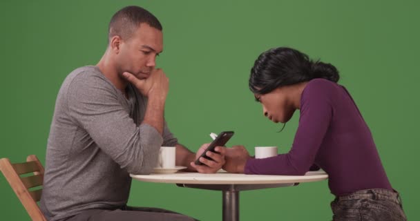 在绿屏上 这对黑人夫妇一边喝咖啡 一边用智能手机上网 在绿色屏幕上键入或合成 — 图库视频影像