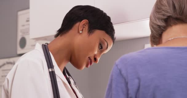Черная Женщина Рентгенолог Обсуждает Результаты Рентгена Зрелой Пациенткой — стоковое видео