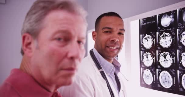 Молодий Розумний Лікар Дивиться Камеру Пацієнтом Середнього Віку — стокове відео