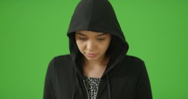 Depresyondaki genç bir kız yeşil ekranda bir portre için poz veriyor. Anahtar ya da birleşik olmak üzere yeşil ekranda.