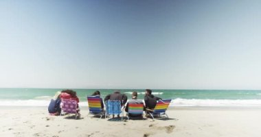 Bir grup arkadaş kumsalda takılıyor.