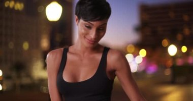 Genç ve seksi Afrikalı bir kadın akşam vakti metropolitan bir şehirde dans ediyor. Muhteşem siyahi kadın dansçı şehir ortamında rahatlatıcı bir dans yapıyor. 4k