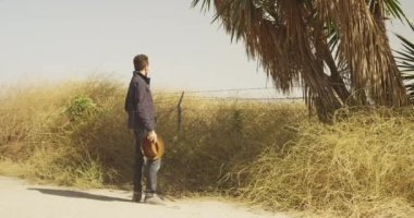 Seksi adam ayakta smartphone ile yolun kenarında