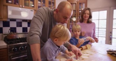 Genç ve güzel bir aile taze kurabiyeler hazırlıyor.