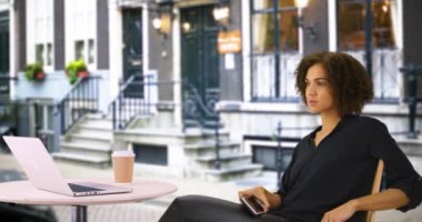 Güzel siyah kadın Londra caddesinde akıllı telefon kullanıyor. Cep telefonu cihazında interneti karıştıran tatlı Afrikalı kadın..