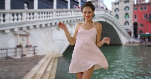 セクシーなラティーナの女性のゆっくりとした動きが風の中でドレスを押し下げ 笑顔と笑っています リアルト橋の近くに立って美しいヒスパニック系の女性の肖像画 — ストック動画
