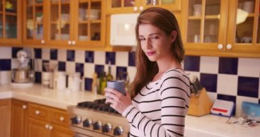 Çekici bir kadın kameraya bakıyor. 20 'li yaşlarda elinde sıcak bir fincan kahve tutan genç bir kadının portresi..