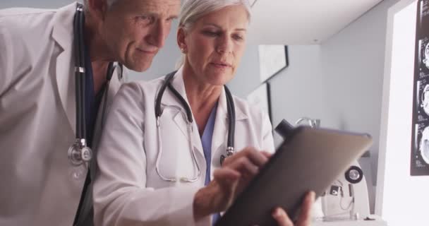 Δύο Μεσήλικες Γιατροί Κοιτάζουν Ένα Δισκίο — Αρχείο Βίντεο