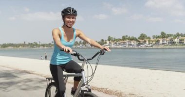 Nehir boyunca bisiklete binen mutlu sağlıklı kadın