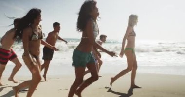 Sağlıklı grup Interracial arkadaşıyla birlikte atlama plaj sahil çalışan