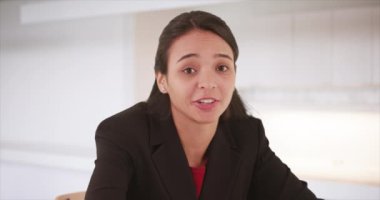 Latin iş kadını konuşuyor ve kameraya bakıyor.
