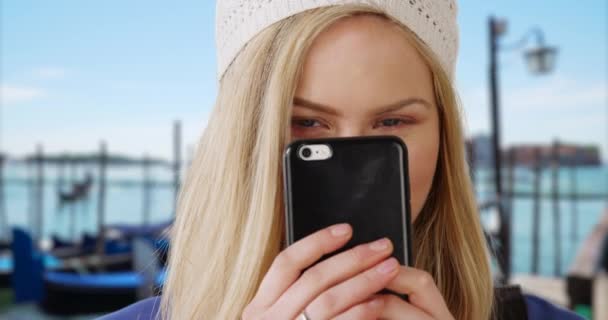 Vacker Blond Kvinna Poserar Lyckligt Med Sin Smartphone Medan Utanför — Stockvideo