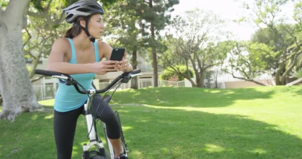 Junge Sportlerin Benutzt Handy Auf Dem Fahrrad — Stockvideo