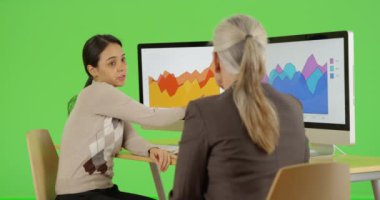 İki ofis çalışanı şirketlerinin istatistikleri hakkında yeşil ekranda konuşuyor. Anahtar ya da birleşik olmak üzere yeşil ekranda.