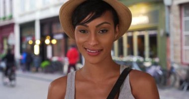 Bruges caddesinde dikilen güzel siyahi kadın kameraya öylesine bakıyor. Çekici bir Afro-Amerikalı kadın Belçika 'da seyahat ederken poz veriyor. 4k