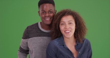 Genç Afrikalı Amerikalı erkek ve kadın yeşil ekranda konuşuyor. Anahtar ya da birleşik olmak üzere yeşil ekranda.