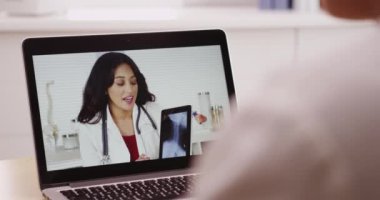 Genç bayan doktor, meslektaşı doktorla görüntülü konuşma yapıyor.