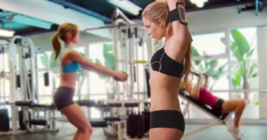 Spor salonunda forma giren üç çekici kadın.