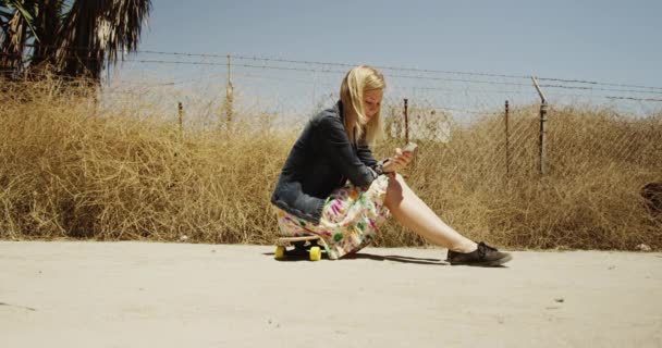 Young Woman Sitting Skateboard Texting — Stock Video