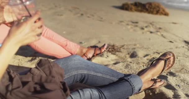 Δύο Μαύρα Γυναικεία Πόδια Φορώντας Σανδάλια Στην Άμμο Της Παραλίας — Αρχείο Βίντεο