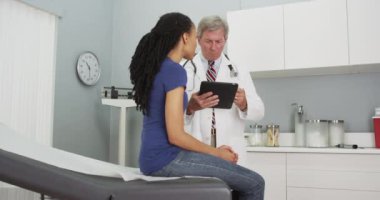 Afrikalı kadın hasta doktoruyla konuşuyor.