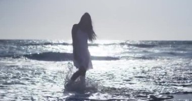 Çekici kadın beyaz elbiseli sahilde dans