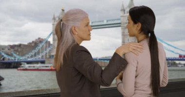 Thames Nehri 'nin orada iş arkadaşları sohbet ediyor. Şefkatli üst düzey kadın yönetici genç iş kadınlarına tavsiye veriyor. 4k