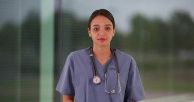 Genç Meksikalı kadın stajyer hastanede koridorda duruyor.